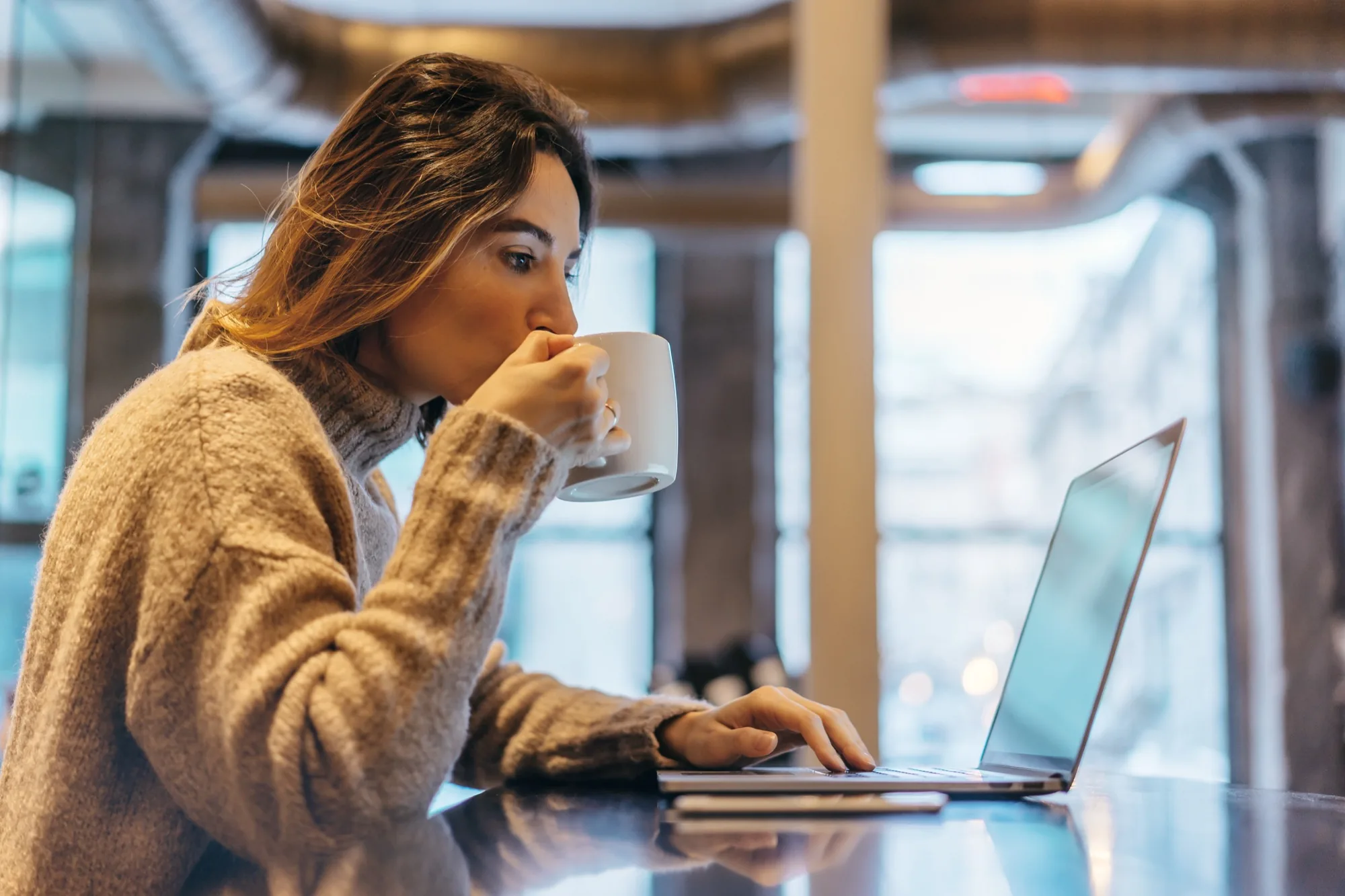A woman with coffee, writing in her private Sholder space